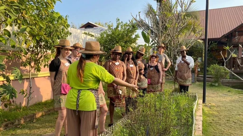 Tourists exploring the herb garden at Siam Garden Cooking School in Chiang Mai