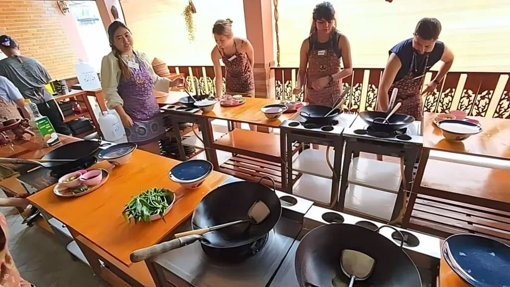 Tourists participating in a Thai cooking class during a Chiangmai Go Tours excursion