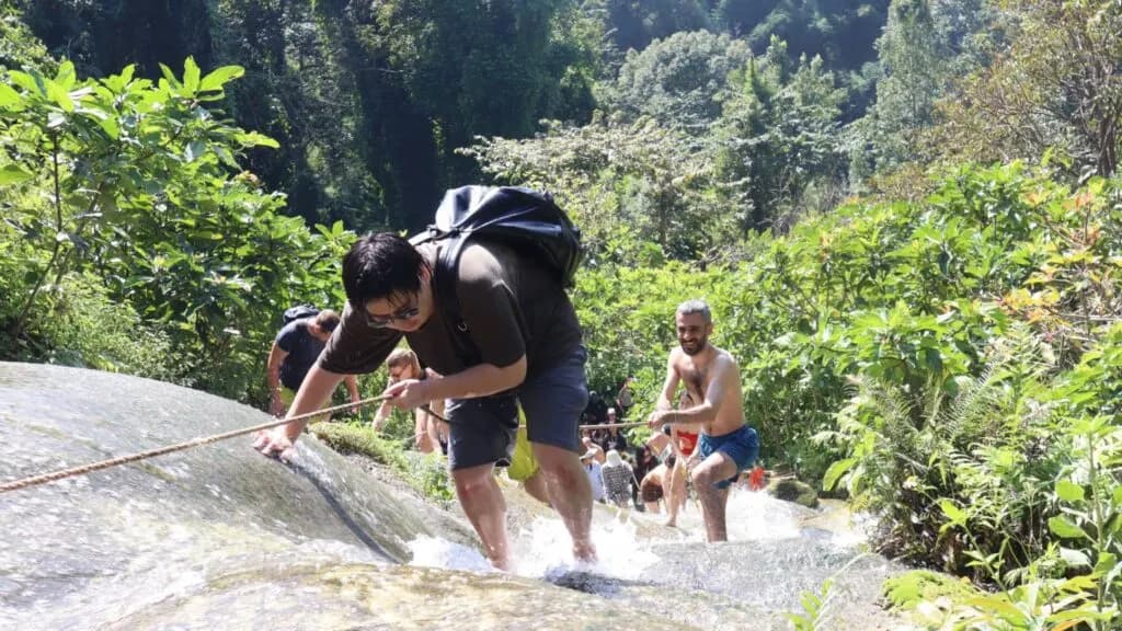 Traveller enjoying a thrilling climb at the Sticky Waterfall on a Chiang Mai tour