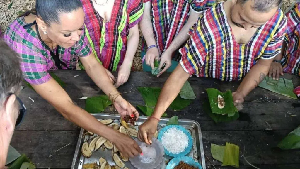 A group of visitors prepares elephant food during a Chiang Mai tour at an elephant
