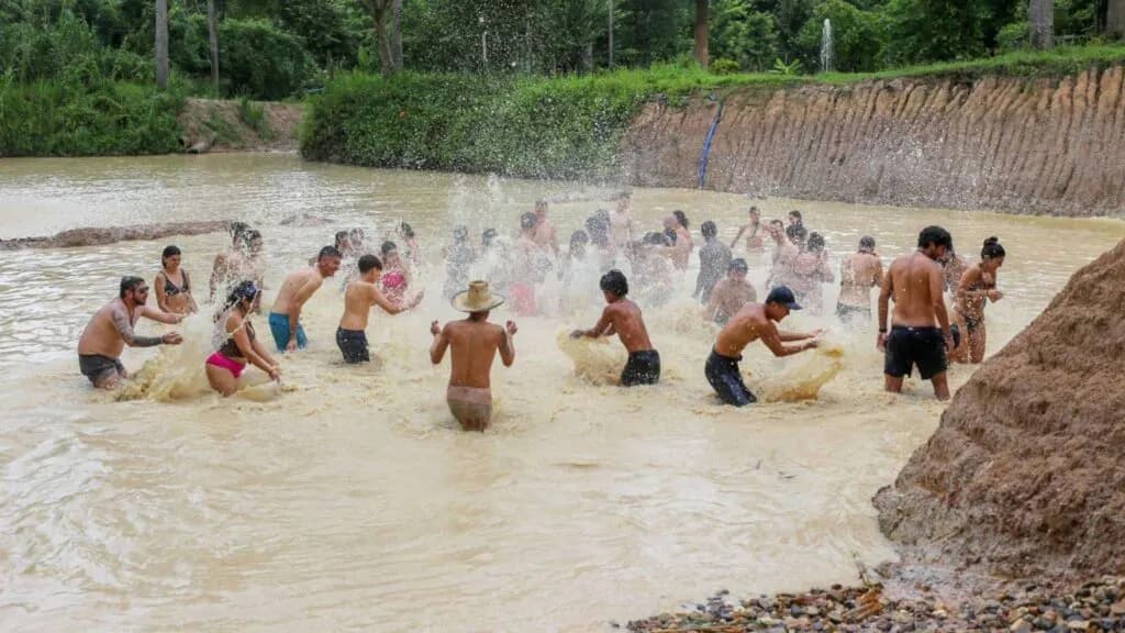 Tourists having a joyful and memorable time bathing in the mud pond.