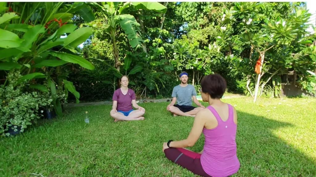Morning outdoor meditation surrounded by tropical plants at a Chiang Mai mindfulness excursion.