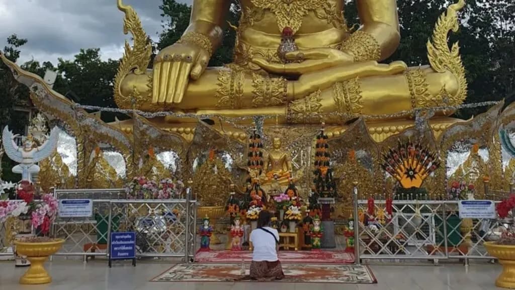 Traveler visiting a golden Buddha temple as part of a Chiang Mai mindfulness retreat and cultural tour