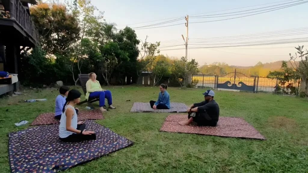 Small group practicing yoga and mindfulness outdoors during a Chiang Mai yoga and meditation retreat.