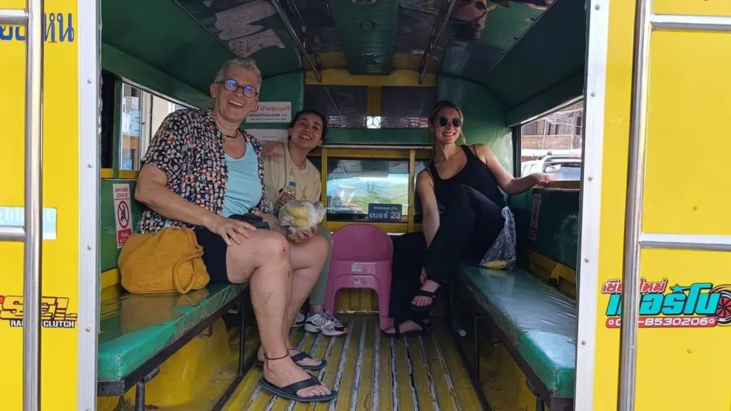 Travelers riding a local Songthaew for transfer during a Chiang Mai yoga and meditation tour.