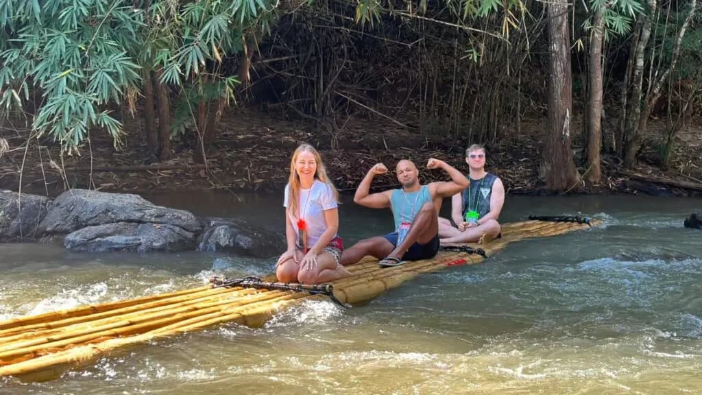 Tourists enjoying bamboo rafting on a jungle river during a Chiang Mai adventure excursion