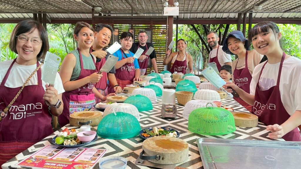 Group preparing to cook in a Thai cooking class during a Chiang Mai tour, a fun Chiang Mai excursion for food lovers.