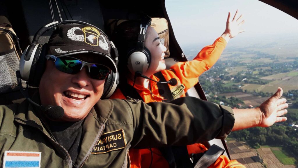Smiling tourist and experienced pilot during a flight, highlighting the fun and adventure of our Chiang Mai excursions.