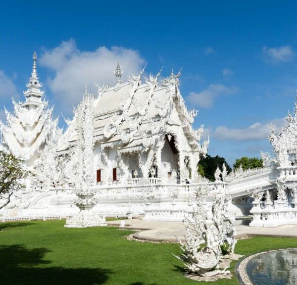 Famous White Temple in Chiang Rai, Thailand, with reflective pond and ornate design
