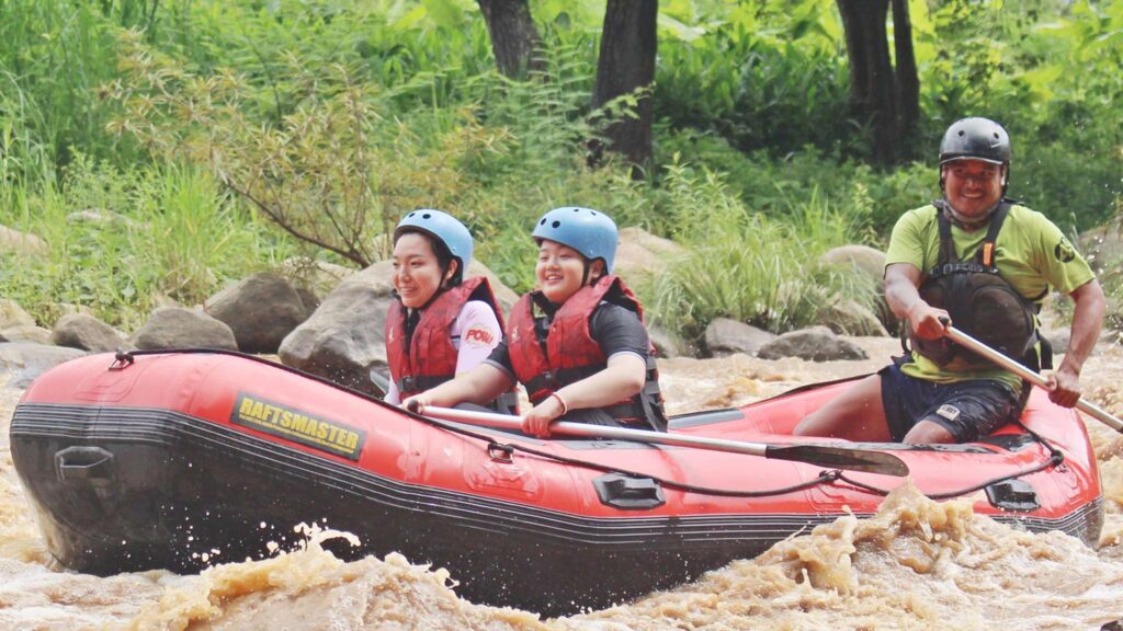 Happy mother and son smiling together while rafting, enjoying a memorable adventure during their Chiang Mai excursion on the water