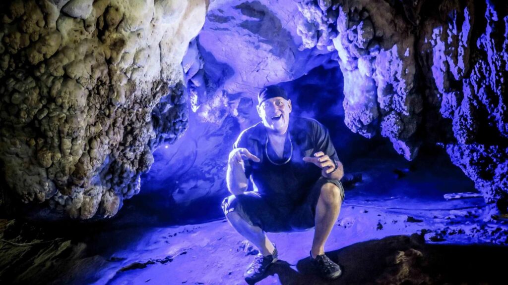 Tourist taking a picture in a dark cave during a Chiang Mai excursion