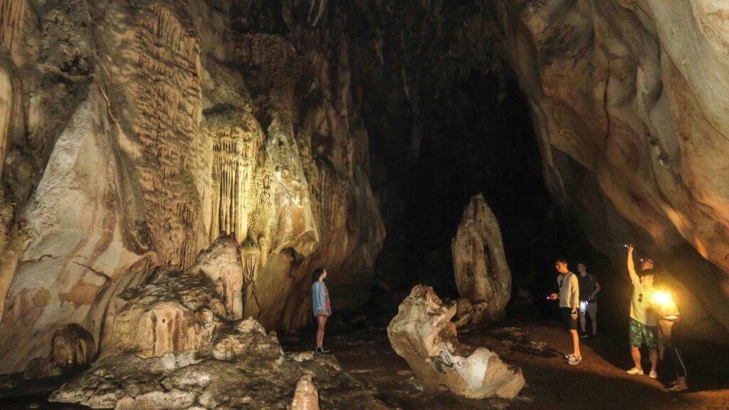 Tourist exploring Chiang Dao Cave on a Chiang Mai tour, marveling at natural limestone formations