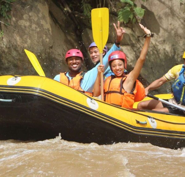 Tourist and guide smiling on a rafting boat during a fun Chiang Mai tour