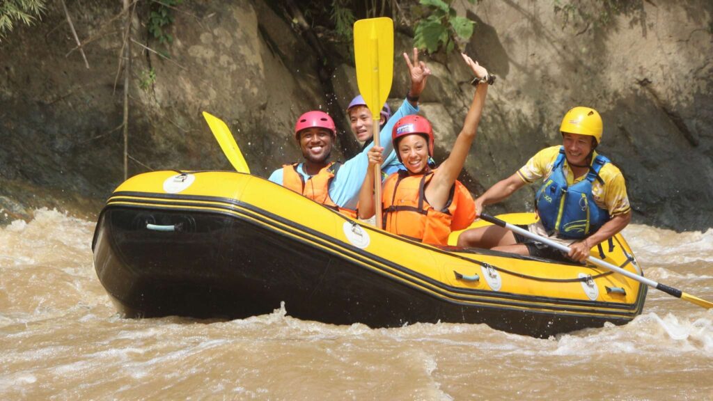 Tourist and guide smiling on a rafting boat during a fun Chiang Mai tour