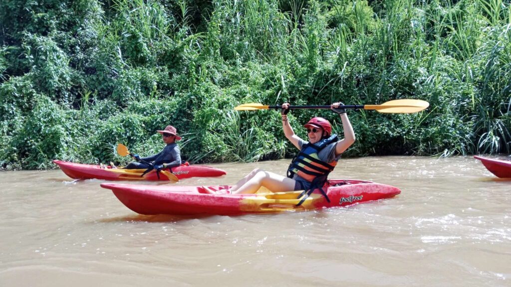 Local guide and tourist kayaking on Mae Ping River during a Chiang Mai tour
