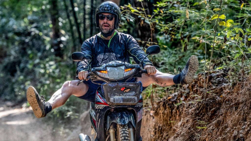 A man riding a scooter off-road during a thrilling Chiang Mai scooter adventure, showcasing the excitement of exploring the city's rugged terrain.