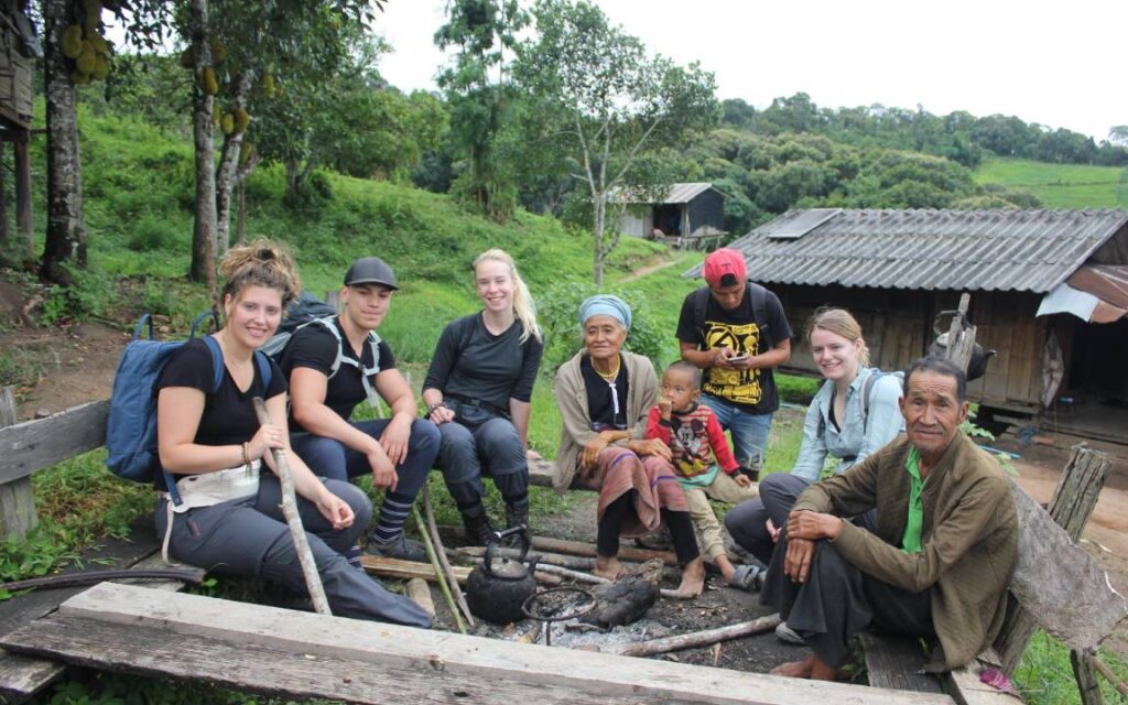 Group of tourists trekking through a local village in Chiang Mai