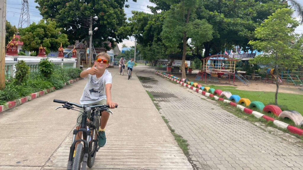Kids and parents riding through a peaceful village