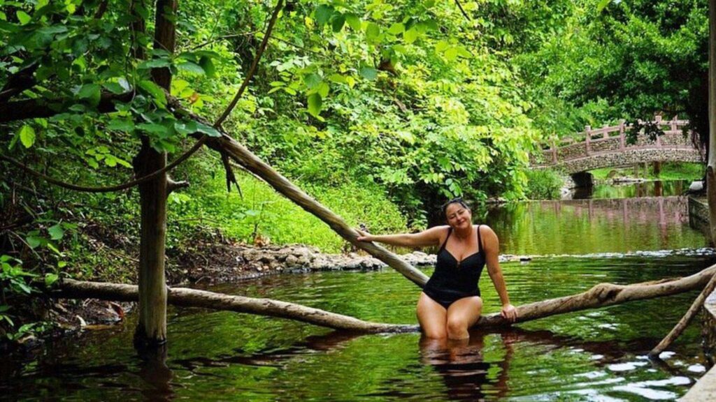 Tourist enjoying the relaxing hot spring in Pai, part of a private transfer experience from Chiang Mai.