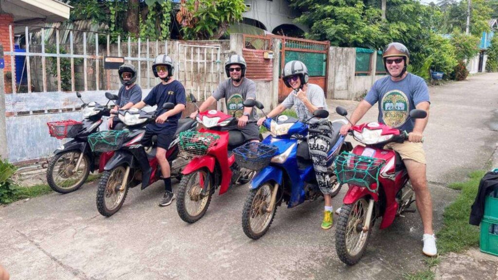 A group of tourists posing for a picture, ready for their adventure during the Chiang Mai Scooter Adventure River Cruise tour.