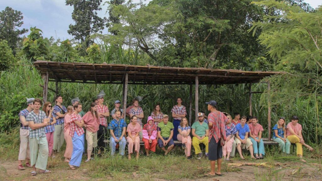 A staff member sharing insights about elephant care with visitors at Maerim Elephant Sanctuary.