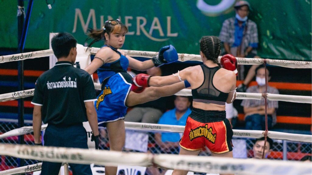 Female Muay Thai fighters delivering powerful kicks in the ring at Chiang Mai Boxing Stadium – a must-see on your Chiang Mai tour.
