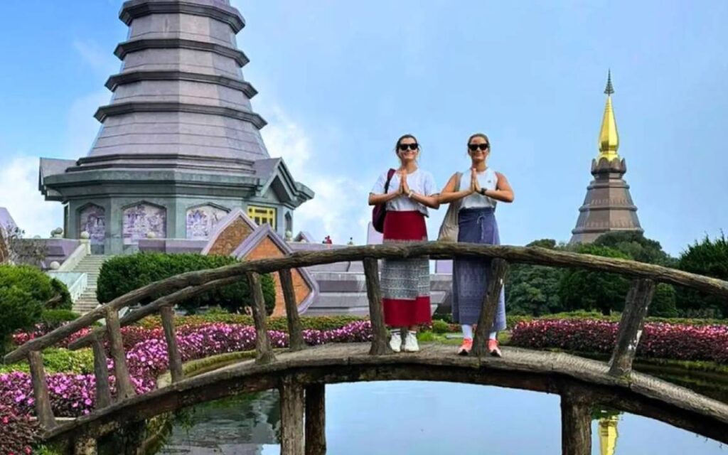 Tourist posting a Thai greeting on a bridge at the Twin Pagodas