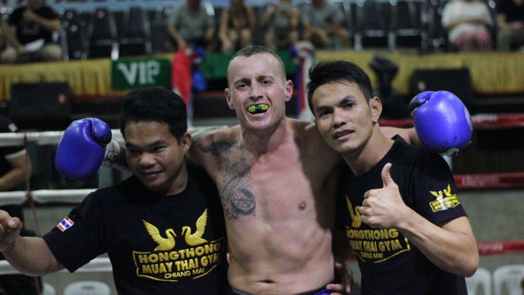 A Muay Thai boxer with his staff preparing for the big fight at Chiang Mai Boxing Stadium during your Chiang Mai tour.