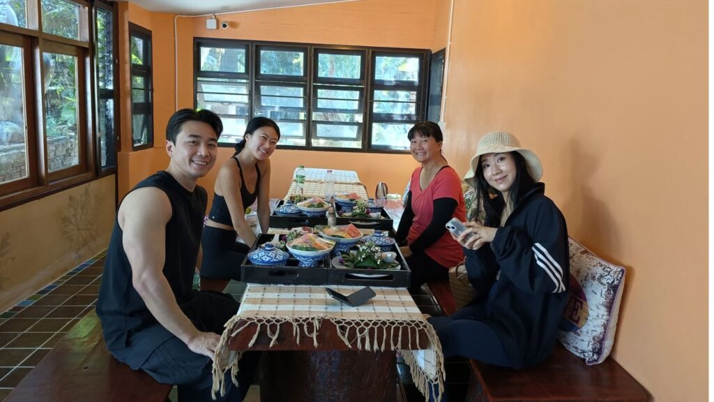 Customers enjoying authentic Thai lunch at a peaceful Chiang Mai meditation and yoga retreat.