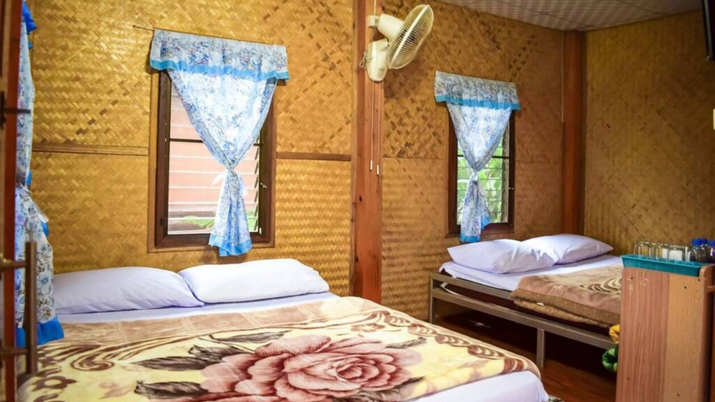 Cozy Karen hill tribe homestay room with simple bedding during Chiangmai trekking overnight tour.