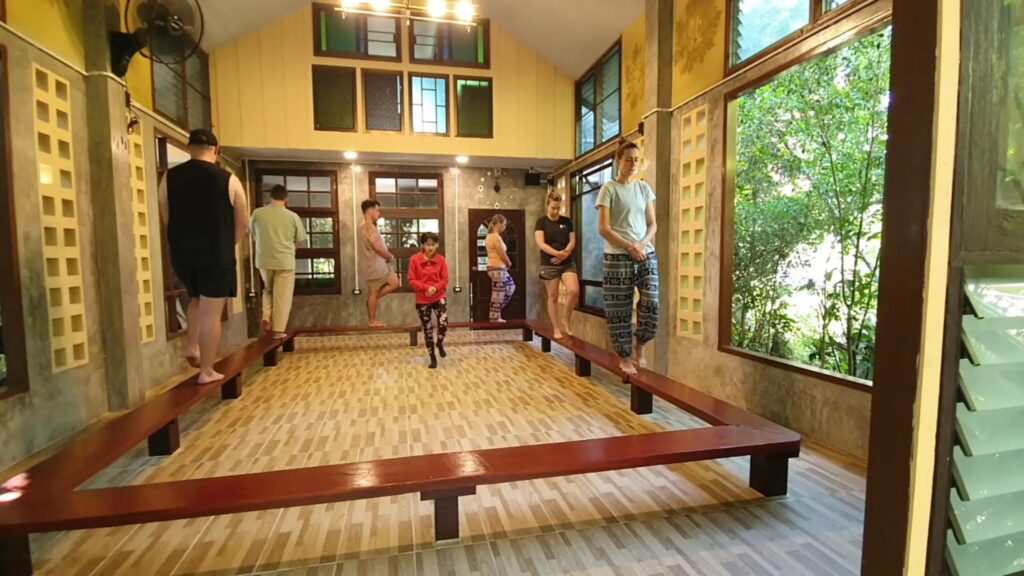 Guests practicing mindful walking meditation inside the Chiang Mai retreat center.
