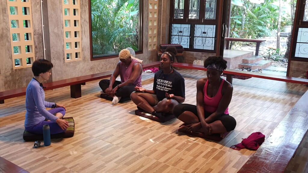 Small group meditation session at a peaceful Chiang Mai retreat center during a wellness tour.